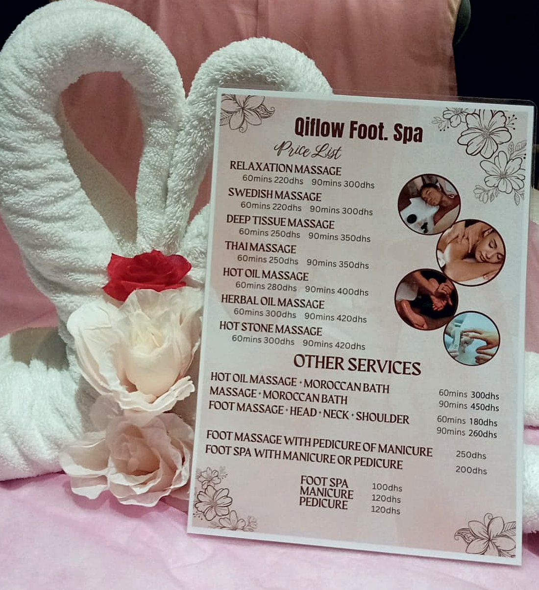 QIFLOW Foot Spa printed price list standing on a treatment bed beside folded towel swans